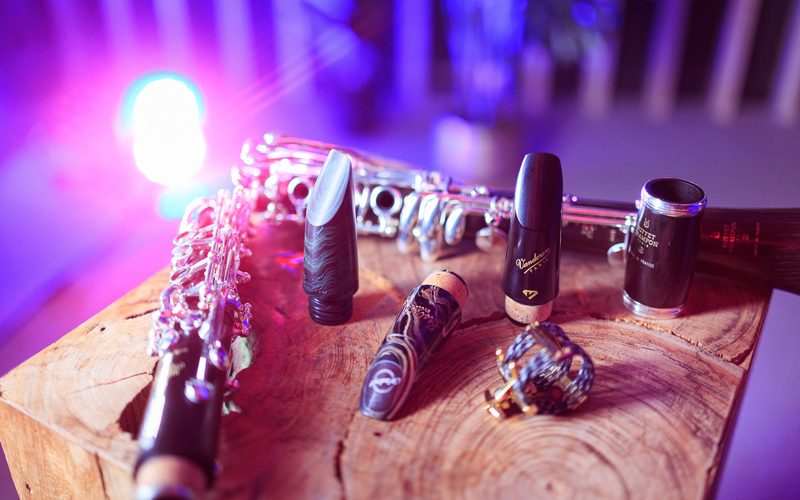 Clarinet mouthpieces, barrels and ligatures laid out on a wooden block