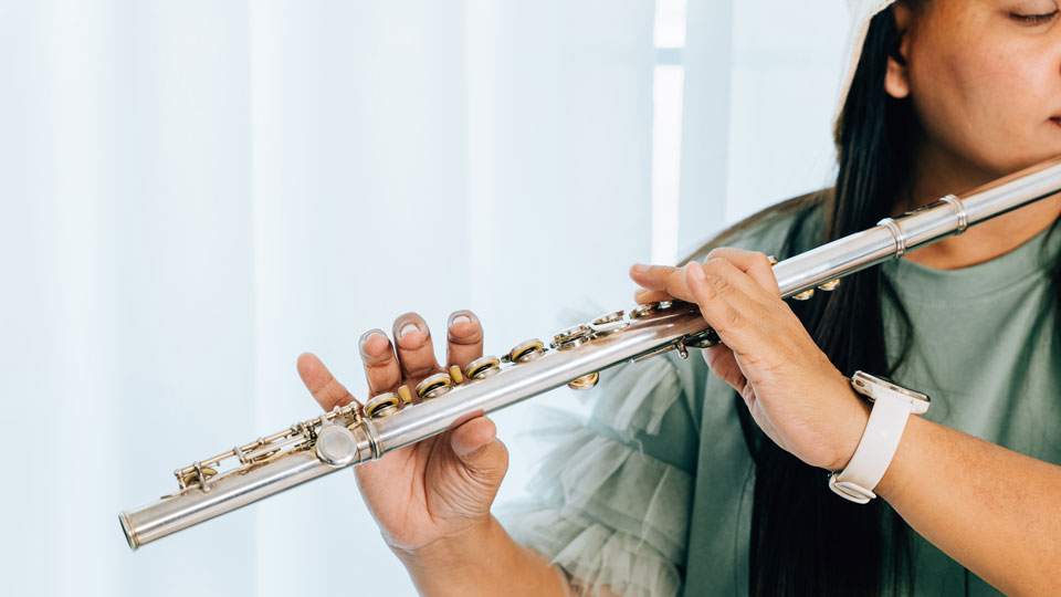 lady playing a flute from the woodwind instrument family